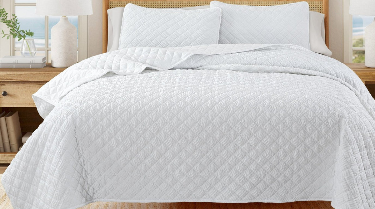 White diamond-embossed quilt set on a bed – quilt vs. comforter vs. duvet