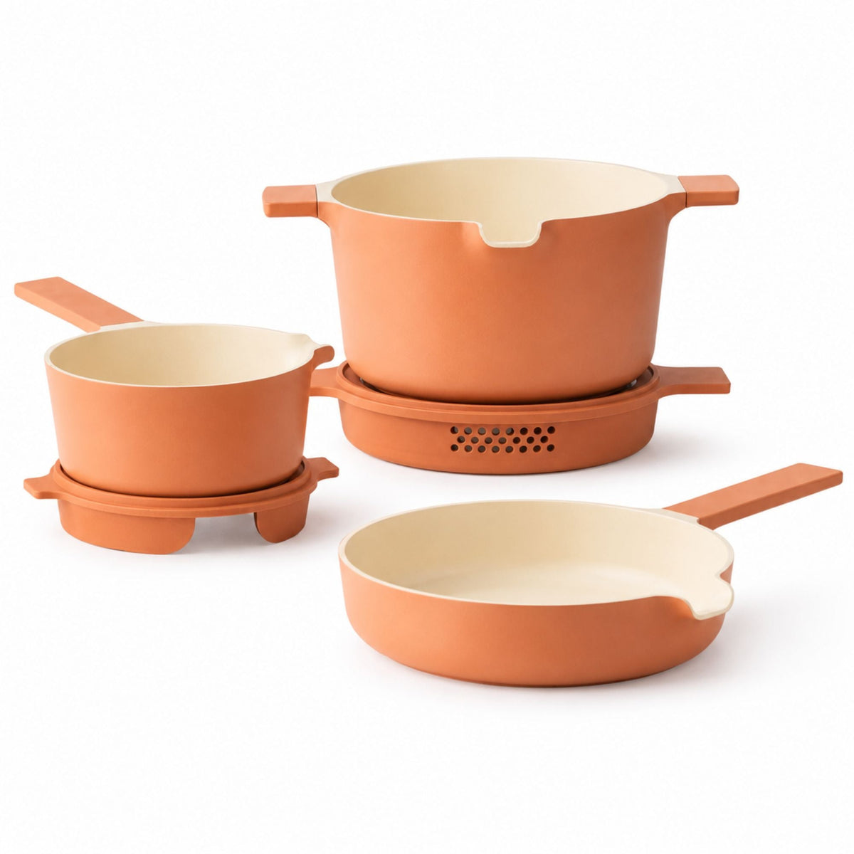 Stacked peach-colored nesting ceramic nonstick cookware set by Alva Cookware, featuring 5 pieces arranged on a white surface.