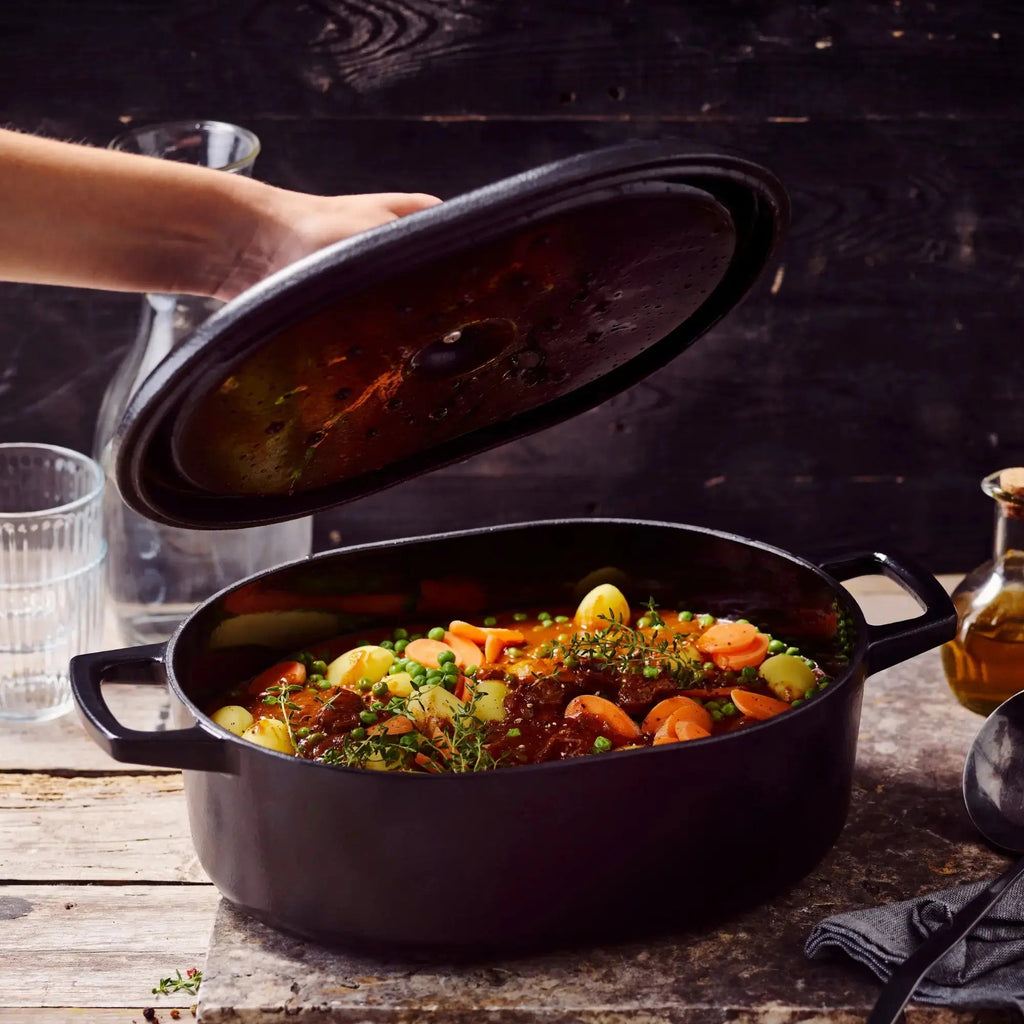 Alva Cookware 6-Qt enameled cast iron oval Dutch oven with braised meal inside, showcasing durable cookware for hearty cooking.