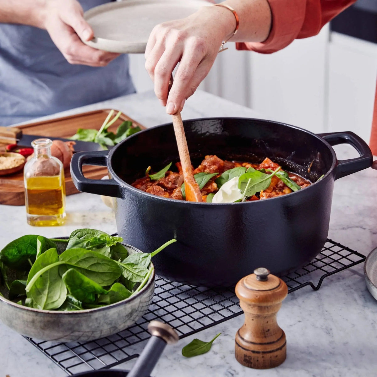 Alva Cookware enameled cast iron round Dutch oven in Nori color, 5-quart size, with vegetable stew inside.