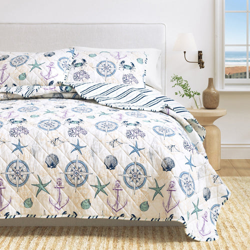 Azure Collection Coastal Quilt Set navy blue maritime quilt with nautical motifs on bed